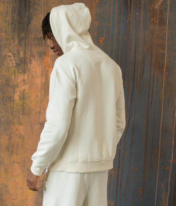 Man in a calm, focused pose against a clay-colored textured background.