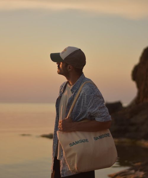 Silhouette of a man standing calmly, looking towards a muted horizon.